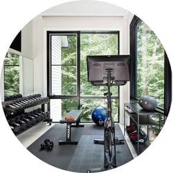 home gym with peloton, weights and black tile