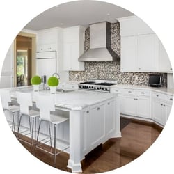 kitchen with beige patterned textured backsplash tile and white granite island with white barstool chairs