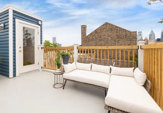 modern farmhouse roof deck remodel with white couch in Graduate Hospital by Bellweather Design Build